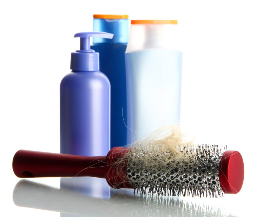 Hair restoration - hair product bottles and hair brush full of blonde hair